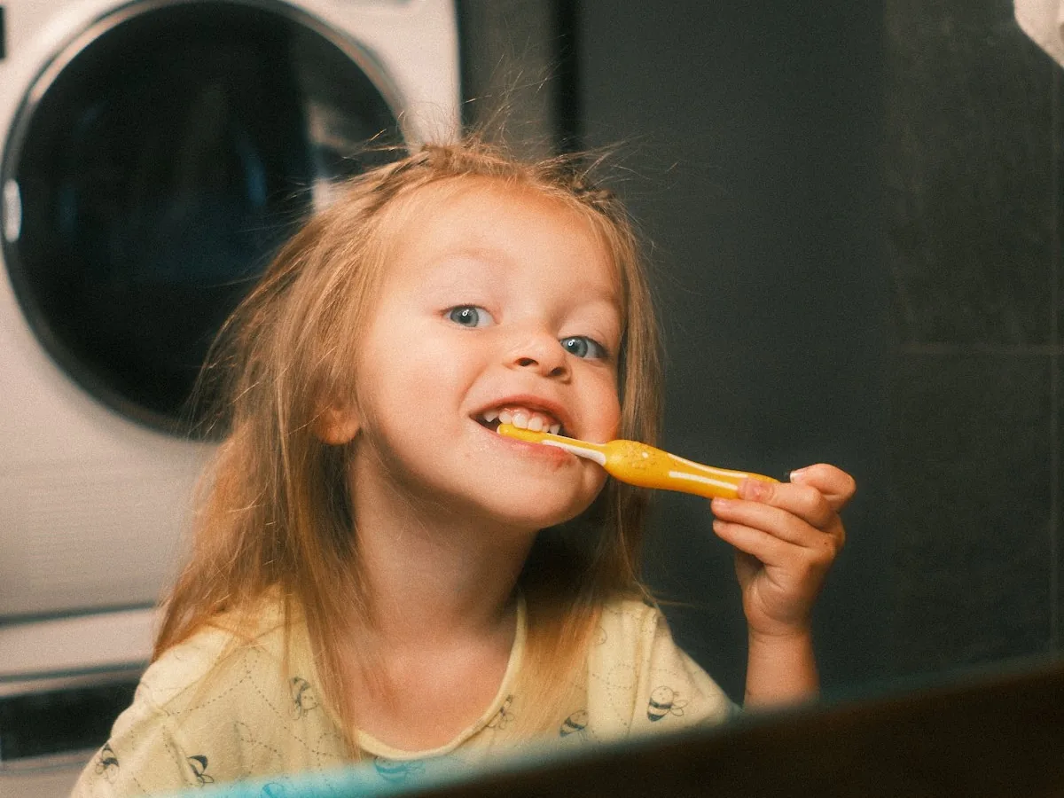Happy child brushing her teeth